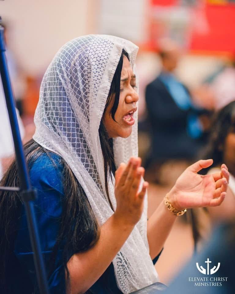 A worshipper in prayer during a service at Elevate Christ Ministries